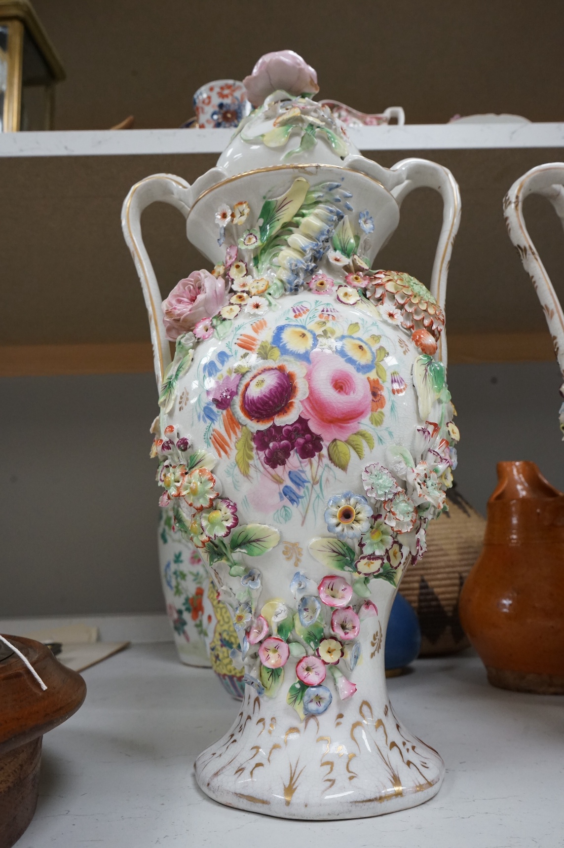 A pair of Victorian Staffordshire porcelain floral-encrusted vases and covers, 44cm high. Condition - some damage